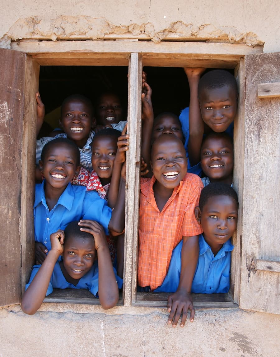 Schoolchildren smiling through a classroom window